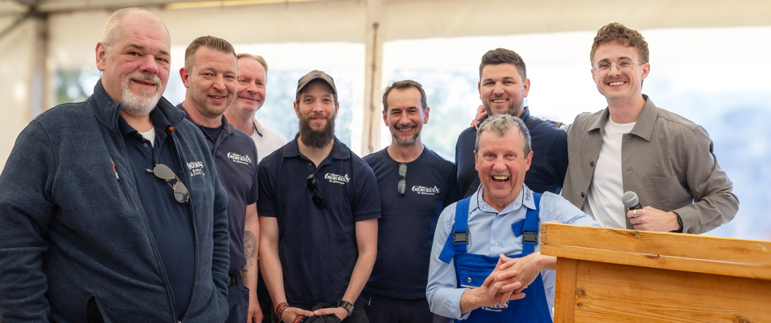 Das Obermonteur-Team der Jan Gerckens Ihr Elektromeister GmbH auf der Bühne beim Firmenjubiläum.